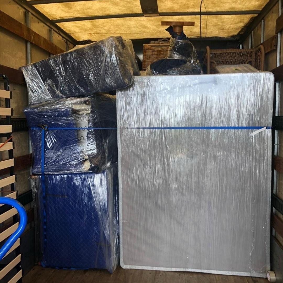 alt="A moving truck filled with protected mattresses and sofas"